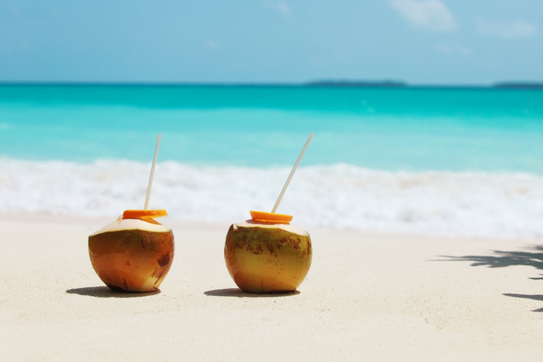 two coconut drinks on tropical beach vacation